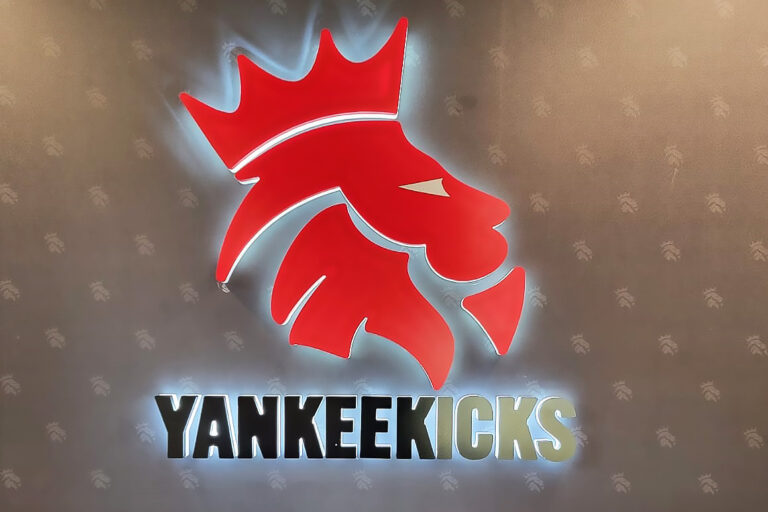 Illuminated red Yankeekicks logo mounted on a wall