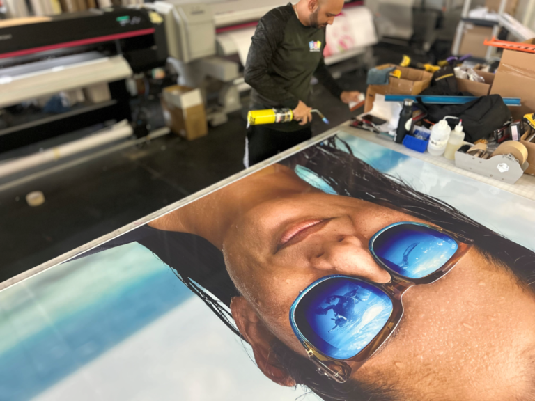 Production team inspecting a large printed portrait