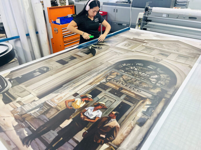 DNA production team member working on a large printed mural