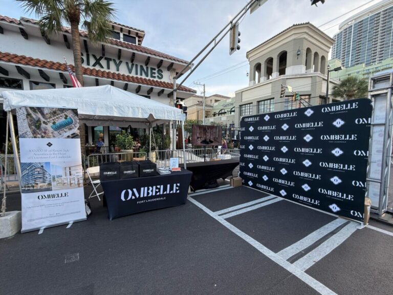 Outdoor event backdrop and branded barricades beside a restaurant