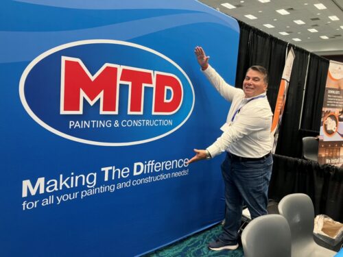 MTD Painting & Construction branded backdrop displayed at an event booth