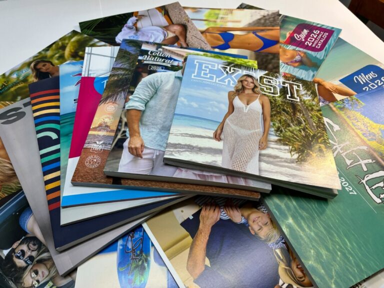 Full-color printed catalogs and booklets arranged on a production table